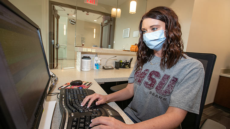 Health services student working in medical office.