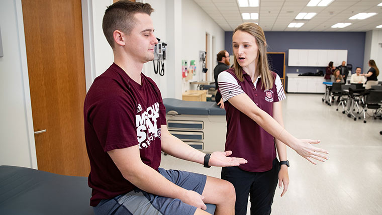 Athletic training student doing demonstration with patient.